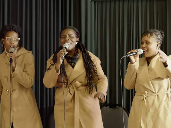 Three women singing together in the Glorious Worship team.